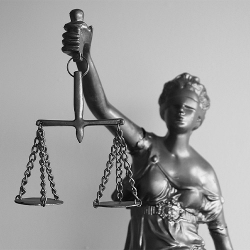 Une statue en metal, symbole de la justice, représentant une femme les yeux bandés tenant dans sa main droite un glaive et dans sa main gauche une balance
