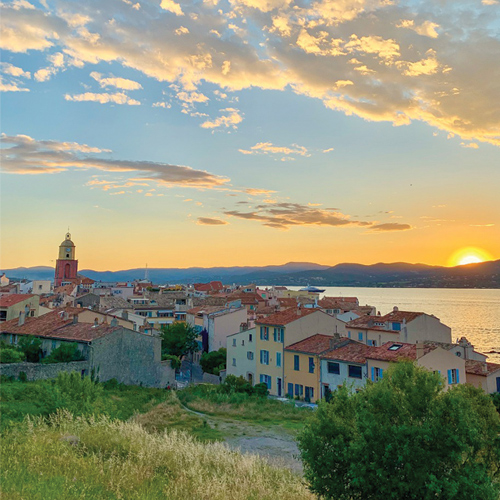 Photo prise en hauteur sur le village de Saint Tropez où il y a un couché de soleil sur les montagnes.