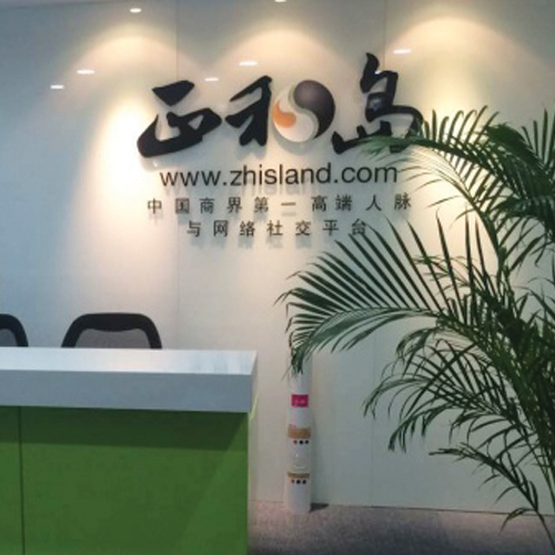 Photo prise au sein des locaux du Club Zhisland de Pékin. Il y a un bureau et des chaises avec écrit le nom de la société en chinois sur le mur.