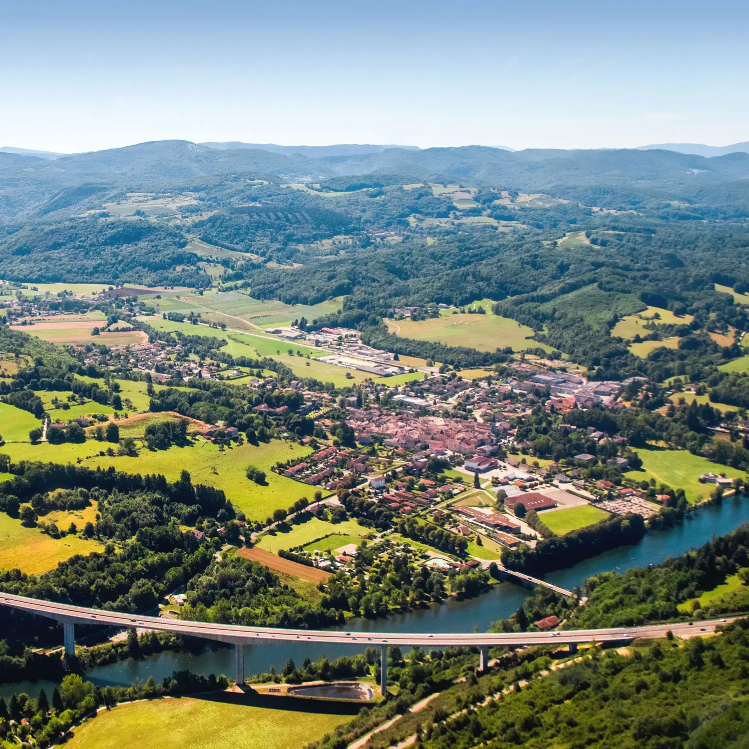Photo prise dans les airs montrant des montagnes et un pont.