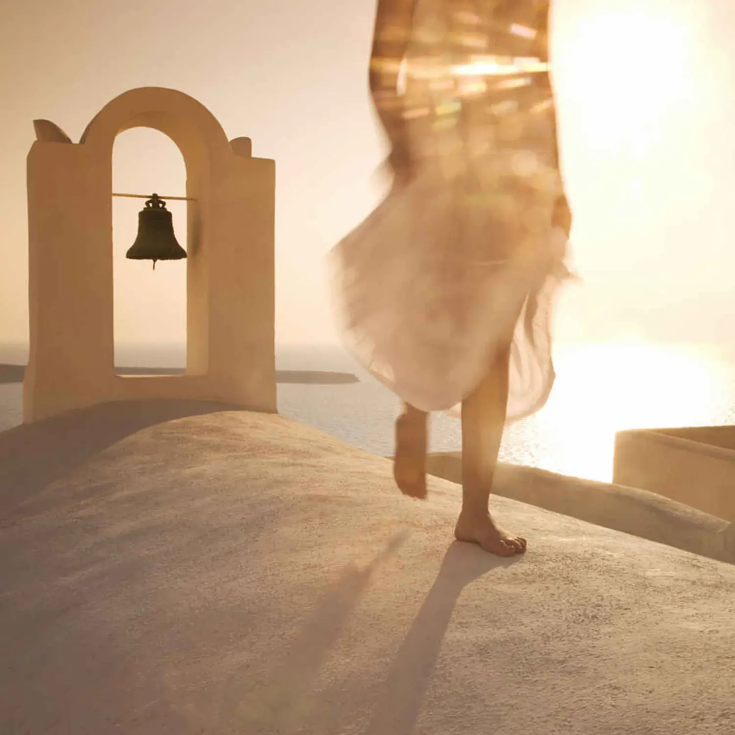 Femme marchant sur le toit d'une maison blanche sur l'île de Santorin