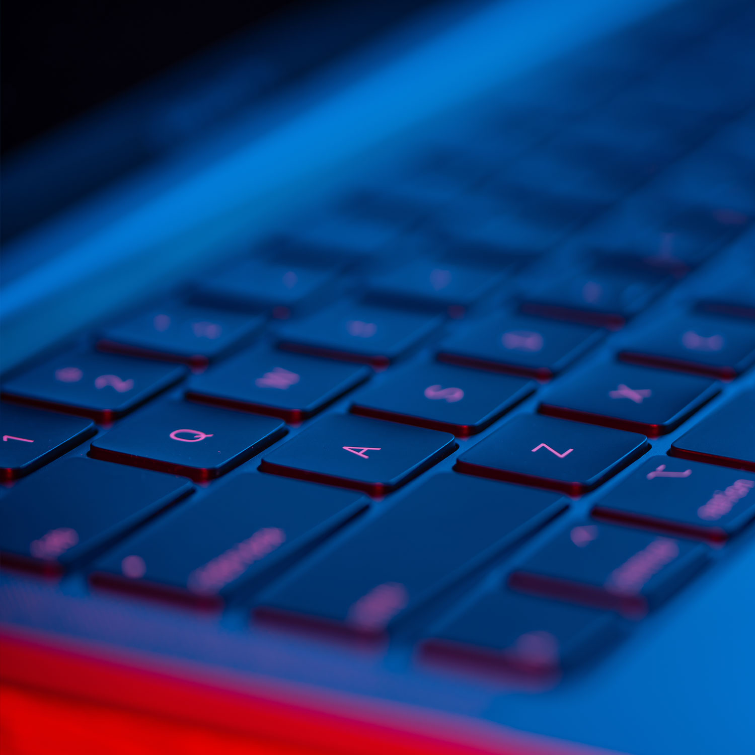 Photo artistique d'un clavier illuminé par un néon rouge